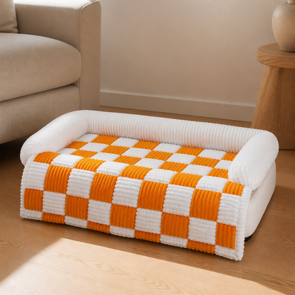 Plaid cozy dog mat styled on sofa, warm afternoon light, tight editorial shot