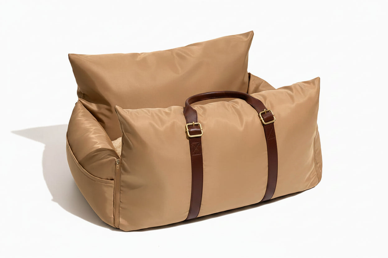Beige duffel bag with brown straps on a white background
