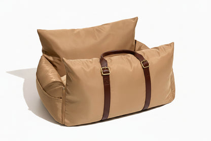 Beige duffel bag with brown straps on a white background