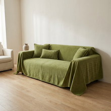 Dog blanket draped on sofa, white oak floor, soft morning light, no animals